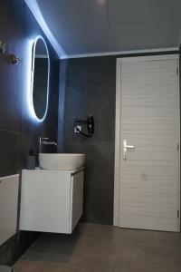 a bathroom with a white sink and a mirror at Casa di Keti - Modern Home with Private Yard ,3 Min to the Beach in Chania