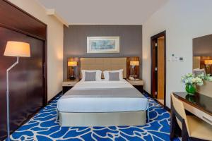 Rúm í herbergi á Hawthorn Extended Stay by Wyndham Abu Dhabi City Center