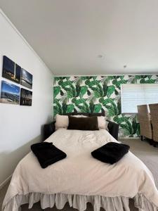 a bedroom with a bed with two black pillows on it at Studio 35 Kerikeri in Kerikeri