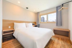 a bedroom with a large white bed and a window at Hotel Moon in Jeju +43 photos