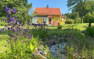 a yellow house with a garden with purple flowers at 2 Bedroom Stunning Home In Broakulla in Broakulla