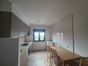 kuchnia ze stołem i krzesłami w pokoju w obiekcie Apartamento A Nave w mieście Fisterra