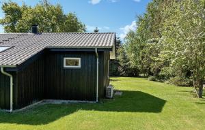 un hangar noir avec une fenêtre dans une cour dans l'établissement 2 Bedroom Stunning Home In Væggerløse, à Bøtø By