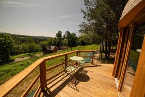 a wooden deck with a table and a table at Leśny krąg in Jamna