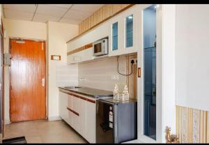 a small kitchen with a stove and a microwave at cozy place-paramount golf forest in Greater Noida
