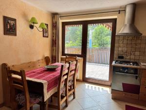 a kitchen and dining room with a table and a window at We are 4810 Chalet Les Crampons in Courmayeur