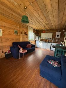a living room with a blue couch and a table at Welcome to Tamara Cottage in Tba