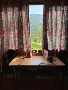 une table avec un ordinateur portable dessus devant une fenêtre dans l'établissement Welcome to Tamara Cottage, à Tba