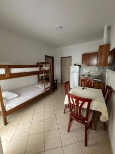 a room with a table and a kitchen with bunk beds at Apartment Radhima in Vlorë