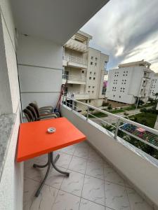 a red table and two chairs on a balcony at Apartment Radhima in Vlorë +13 photos