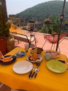 a yellow table with plates of food on it at La Casa Stregatta in Sassetta +16 photos