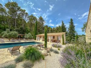 a backyard with a pool and a house at Mas Leblanc des Alpilles in Saint-Étienne-du-Grès