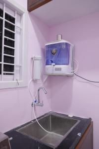 Un fregadero de cocina con una tostadora en la pared. en AK Residency, en Chennai