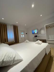 a bedroom with two beds and a tv on the wall at Odore di Mare in Qeparo