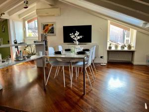 a dining room with a table and chairs at Vanessa's Art Rooftop Attic - City View - San Fedele, Historic Center Como in Como +27 photos