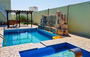 a swimming pool with a slide in a building at استراحة الاصالة alasalah in Ţaymissah