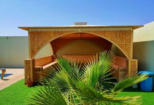 Ţaymissahにあるاستراحة الاصالة alasalahのシェルターとその前に植物がある建物