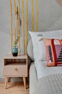 a bed with a night stand next to a side table at Letnica Seaside by Downtown Apartments in Gdańsk