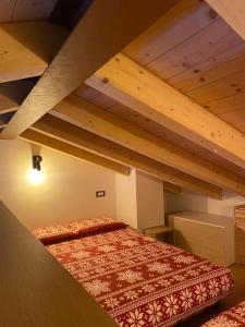 a bedroom with a bed in a loft at Baita Bea&Benny in Carona