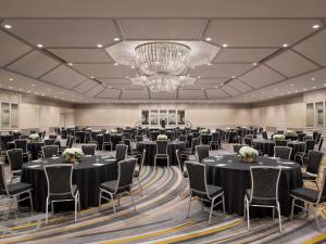 a ballroom with tables and chairs and a chandelier at Fairmont Chicago Millennium Park in Chicago