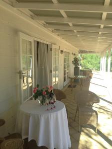 
a table with chairs and a table with flowers in it at Llewellin's Guest House in Margaret River Town
