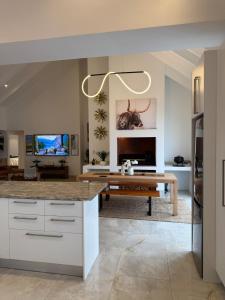a kitchen with a table and a living room at Hermanus Villa in Hermanus