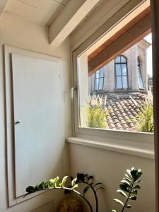 a window in a room with a plant at Vanessa's Art Rooftop Attic - City View - San Fedele, Historic Center Como in Como