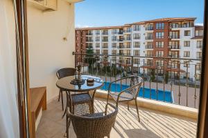 a balcony with a table and chairs and a view of a building at Apolon-7 Sea Breeze Apartment in Nesebar