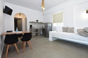 a living room with a bed and a table and chairs at Muses Rooms Milos in Provatas +37 photos