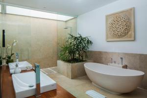 a bathroom with a large tub and a sink at Luxury 5BR Canggu Villa with Private Pool, Rice Fields View & Beach Nearby - The Palm House in Canggu