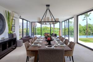 a dining room with a long table and chairs at Luxury 5BR Canggu Villa with Private Pool, Rice Fields View & Beach Nearby - The Palm House in Canggu +18 photos