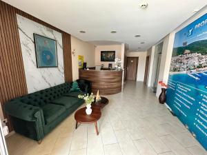a living room with a green couch and a table at Horizont Apartments in Sunny Beach