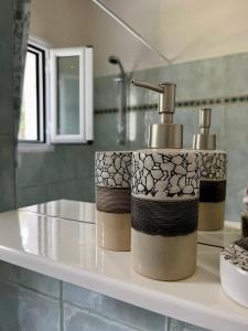 a kitchen counter with a sink with two stacks of paper towels at Beachfront Villa with Garden - Valentine Corfu in Mesongi