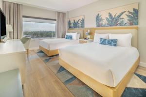 A bed or beds in a room at Radisson Resort Miami Beach