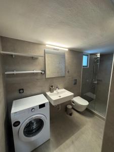 W łazience znajduje się pralka i umywalka. w obiekcie Remvi Suite in Chania w mieście Xamoudhokhórion
