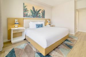 A bed or beds in a room at Radisson Resort Miami Beach