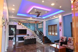 a staircase in a living room with a blue ceiling at Brownstones Resort in Kanthalloor