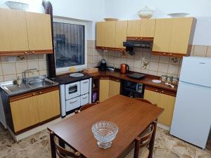eine Küche mit einem Holztisch und einem Kühlschrank in der Unterkunft Lyberty in Randazzo