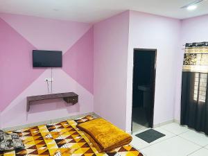 a room with a bed and a tv on a wall at SP Villa & Homestay - For Couples, Students, Faculties, Family in Phagwāra