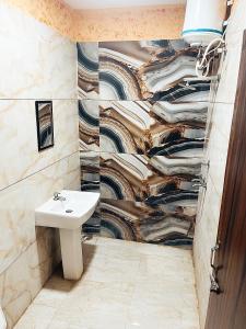 a bathroom with a sink and a mural at SP Villa & Homestay - For Couples, Students, Faculties, Family in Phagwāra