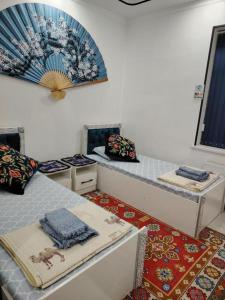 Habitación con 2 camas y almohadas. en KAMIR Guest House, en Bukhara