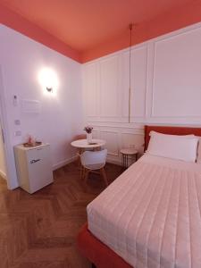 a bedroom with a large bed and a table at Ortocastello Comfort Rooms in Gela