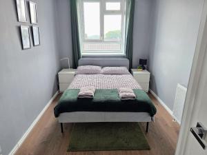 een bed in een kleine kamer met een raam bij Beautiful 3-bed apartment at Swiss Cottage in Londen