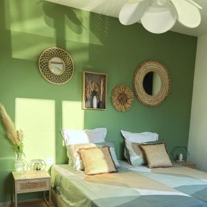 1 dormitorio con paredes verdes y 1 cama con almohadas en Casa Lucia, en Aléria