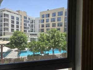 a window with a view of a pool and buildings at 2BR Luxury Apartment in Al Zahia Pool View by BlueCloud holidays in Sharjah
