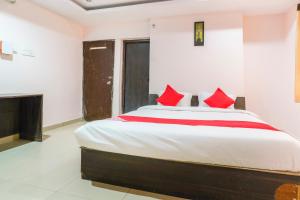 a bedroom with a large bed with red pillows at Spot On Sunshine Inn in Hyderabad