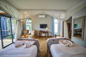 Un dormitorio con dos camas y una sala de estar. en Pamoja Farm Villas, en Karatu 49 fotos más