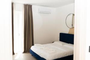a bedroom with a bed with a mirror and a window at Kāma in Bari Palese