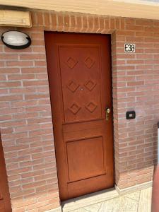 a brown door in a brick building with a brick wall at Residence IL BORGO 38 in Tortoreto Lido