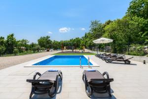 a swimming pool with lounge chairs and a playground at Villa Laura by Briskva in Ripenda Kras